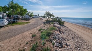 A beachside RV park with clear skies and calm waters.