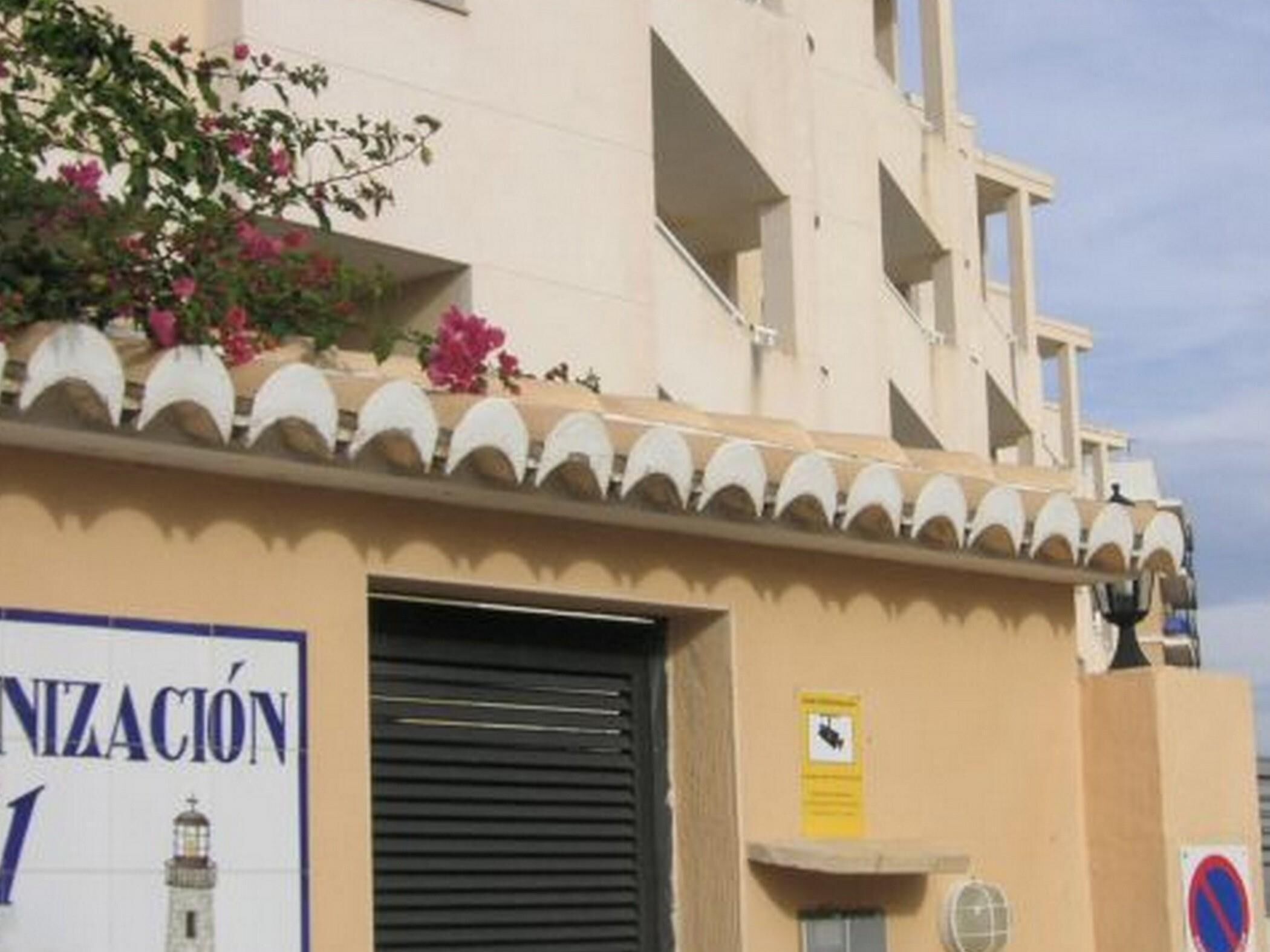 A building with a sign reading "NIZACION" and a closed shutter door.