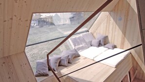 A wooden interior with a sloped ceiling and a view of the outdoors. - Experience the special (Nußdorf/Debant)