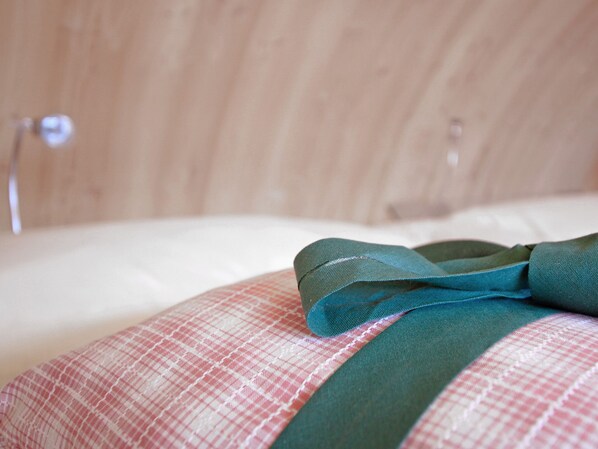 A bed with a plaid pillow and a teal ribbon. - Experience the special (Nußdorf/Debant)
