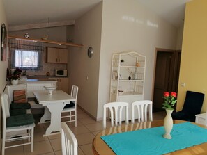 Un comedor con una mesa, sillas y un jarrón de flores.