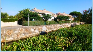 Un barrio residencial con casas, un muro de piedra y vegetación.