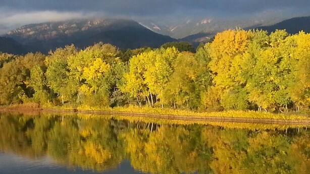 A calm lake reflecting yellow trees and distant mountains. - Charming Cheyenne Cañon Cottage, Steps To The Broadmoor & Seven Falls! (Colorado Springs)
