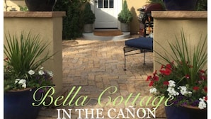A cottage with a stone patio, a door, and potted plants. - Charming Cheyenne Cañon Cottage, Steps To The Broadmoor & Seven Falls! (Colorado Springs)