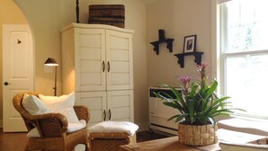 A living room with wicker furniture, a white cabinet, and a potted plant. - Charming Cheyenne Cañon Cottage, Steps To The Broadmoor & Seven Falls! (Colorado Springs)