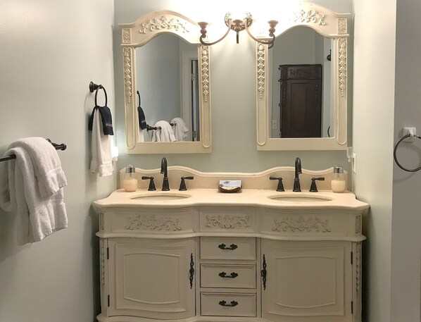 A bathroom with a double sink vanity, two mirrors, and a towel rack. - Bay View Villa 109, 3/2 Condo, Waterfront, Gated, Pool, Tennis, sleeps 8 (Tybee Island)