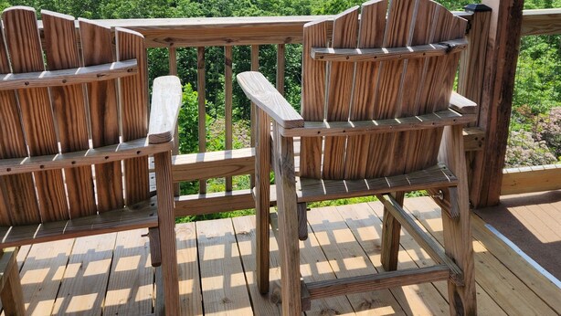A wooden deck with two chairs and a table, overlooking a lush green landscape with distant mountains. - Two King Suites! Endless View!  Close to Town. All paved roads. Pet Friendly. (Blue Ridge)
