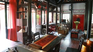 Un interior tradicional con zona de comedor, un conjunto de sofás y una puerta roja.