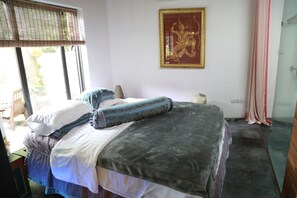 A bedroom with a bed, pillows, a framed picture on the wall, and a window with blinds. - Maison Haily (Hanoi)