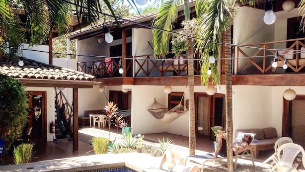 Una piscina al aire libre, sombrillas, sillones reclinables de piscina