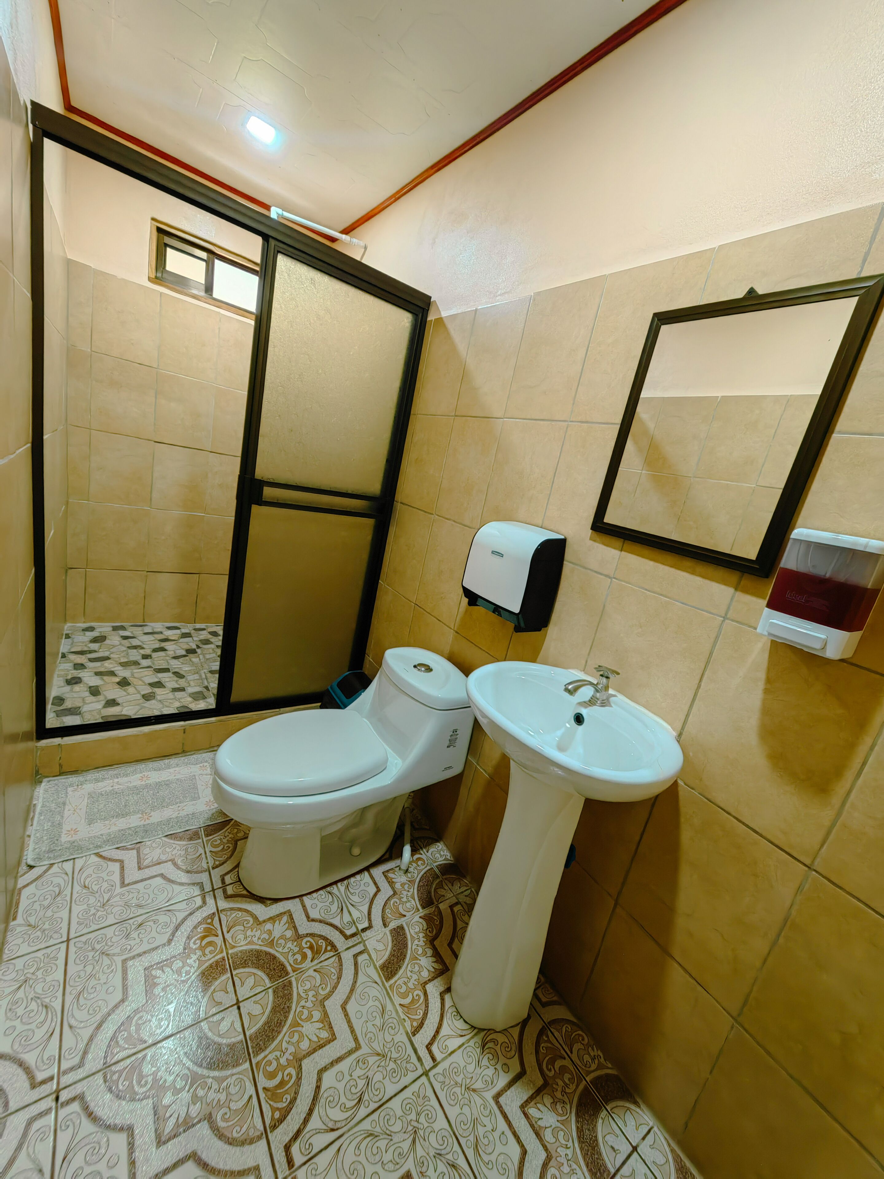 A bathroom with a toilet, sink, and a mirror.
