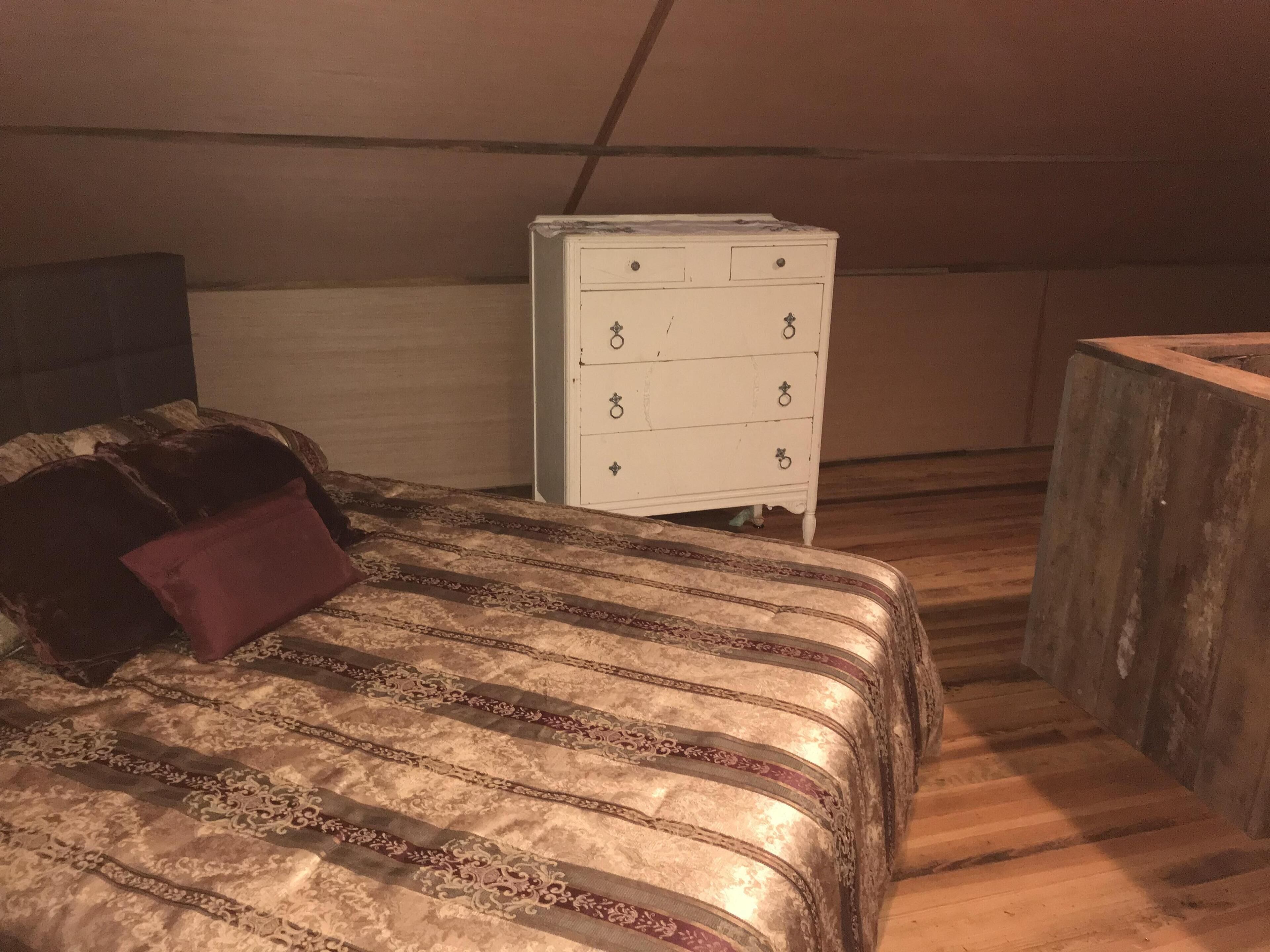 Ein Schlafzimmer mit einem Bett, einem Schminktisch und einer hölzernen Bank.