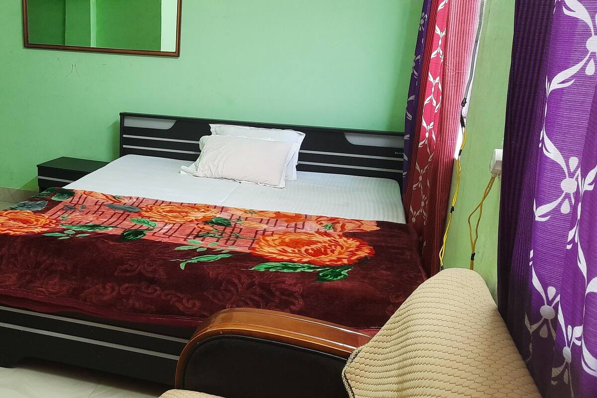 Ein Schlafzimmer mit Bett, Nachttisch, Kommode und Spiegel an der Wand.