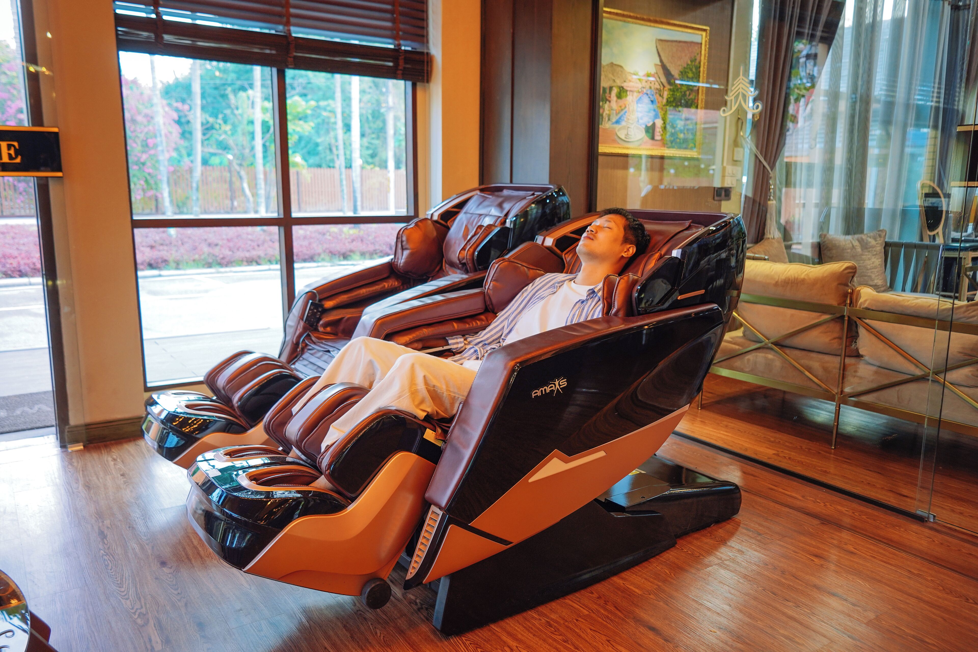 Un fauteuil de massage dans une pièce dotée de grandes fenêtres donnant sur l’extérieur.