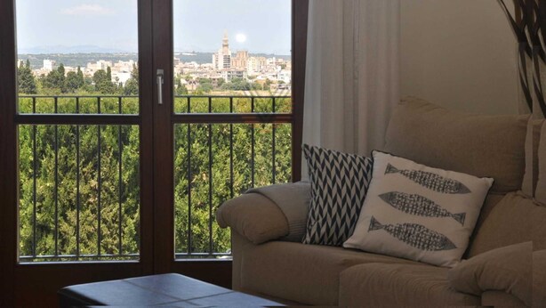 A living room with a view of a cityscape through a large window. - Villa close to Rafa Nadal Center in Manacor (Manacor)