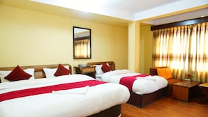 A hotel room with two beds, a sofa, a small table, and a mirror. - Hotel Holy Temple Tree & Chautari Cafe (Kathmandu)