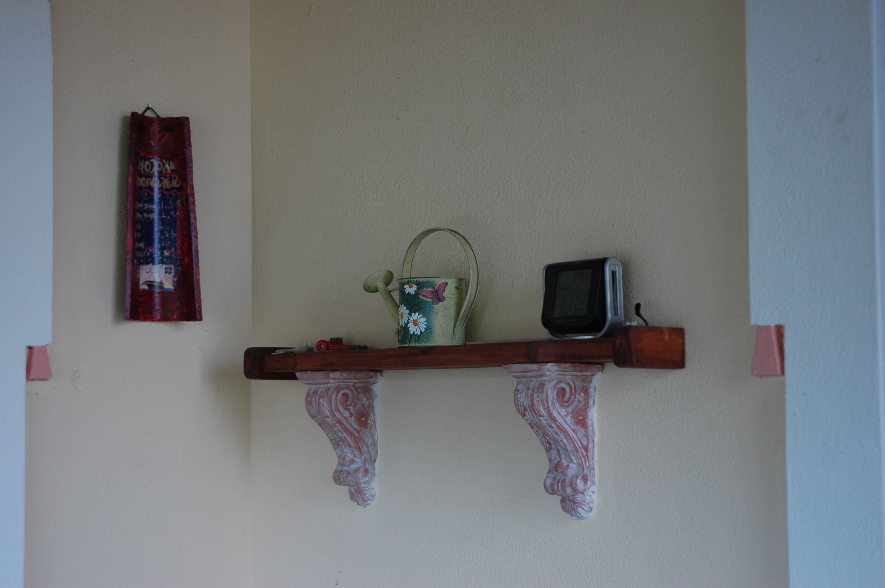 Una estantería con un objeto decorativo, un televisor pequeño y un objeto enmarcado.
