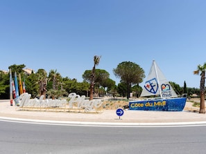A coastal area with a sailboat named 'Côte du Midi' and a signpost with the same name.