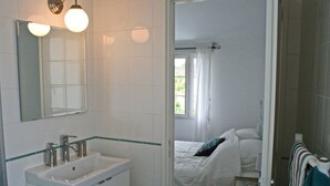 A bathroom with a sink, mirror, and two wall-mounted lights.