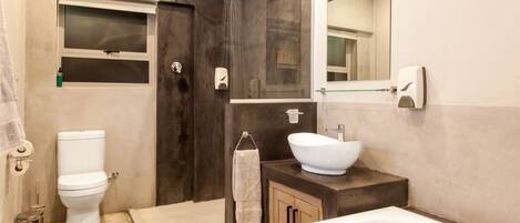 A modern bathroom with a bathtub, a toilet, a shower, and a sink.