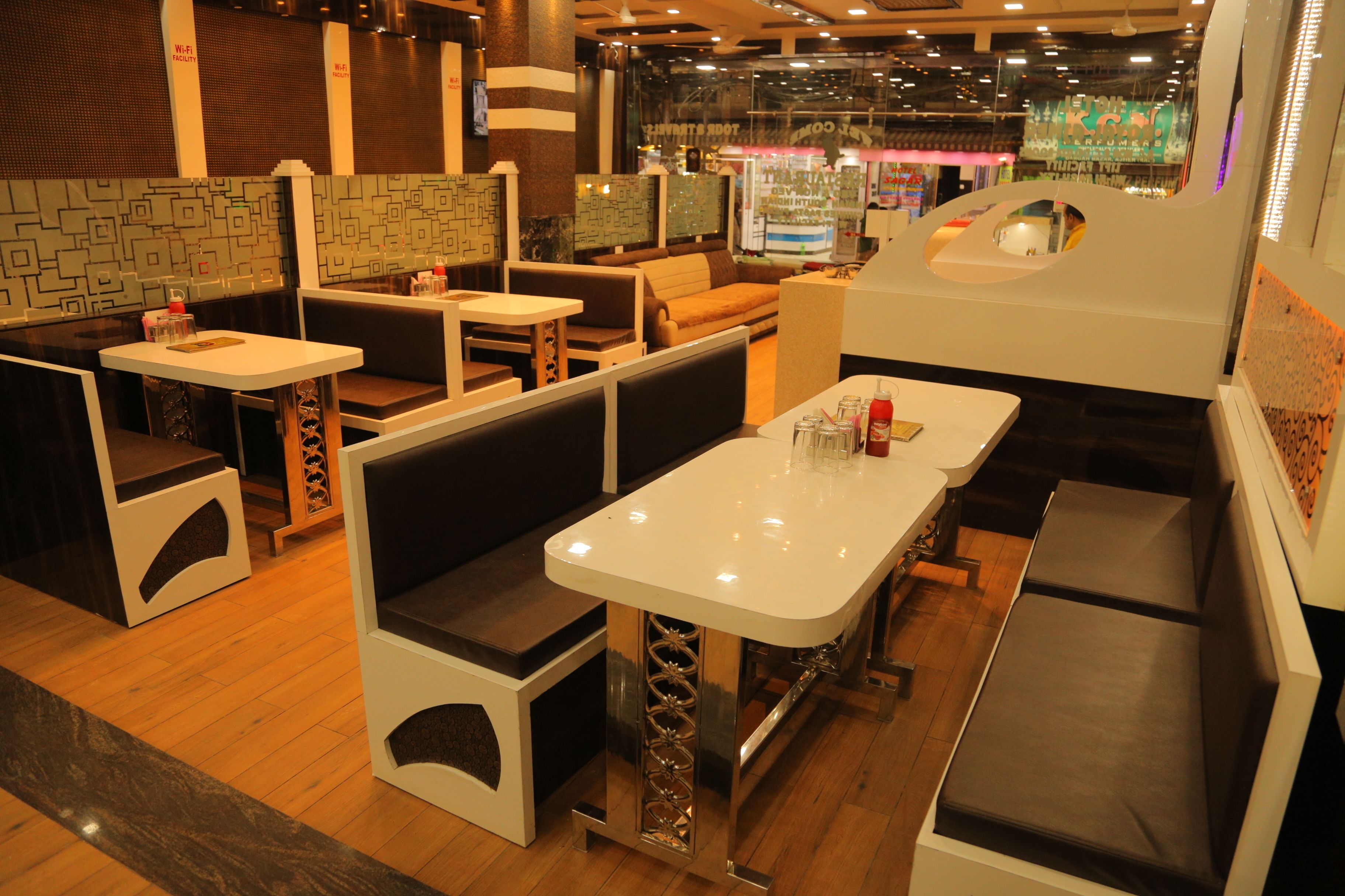 Un restaurante con asientos tipo cabina, mesas y una zona de bar.