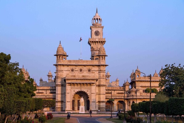 Un edificio grande e histórico con una imponente torre de reloj y una entrada con arco.