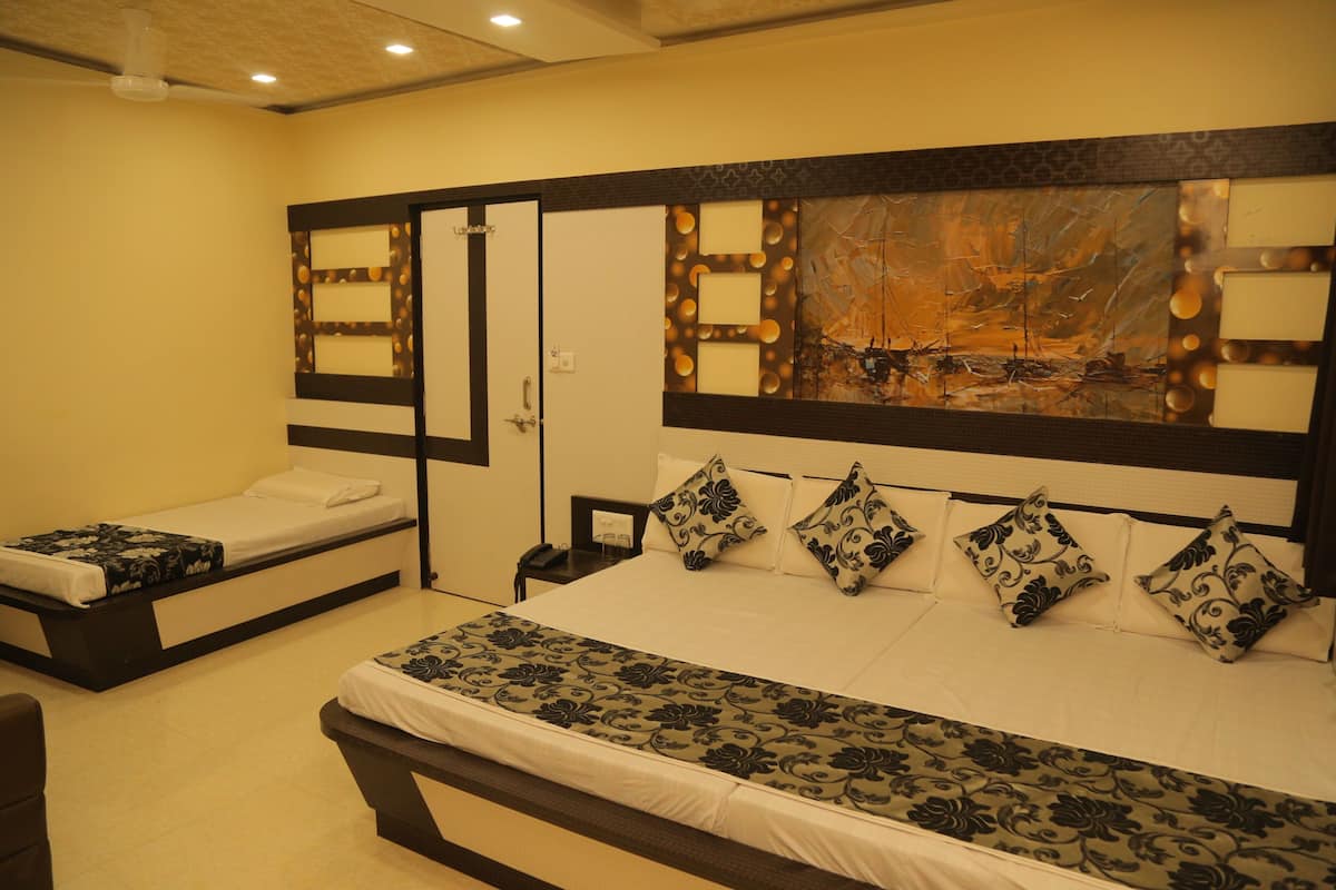 A hotel room with a large bed, a smaller bed, a nightstand, and a mirror.