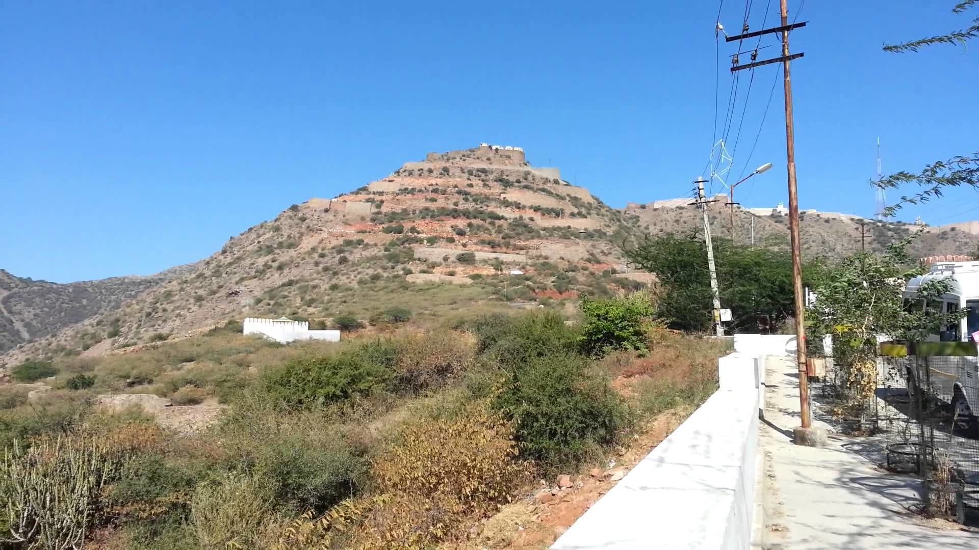 A mountainous landscape with a white building on a hill.