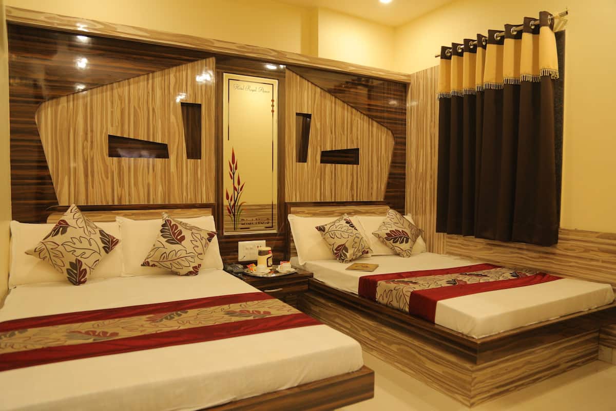 A hotel room with two beds, a wooden headboard, a mirror, and a window with curtains.