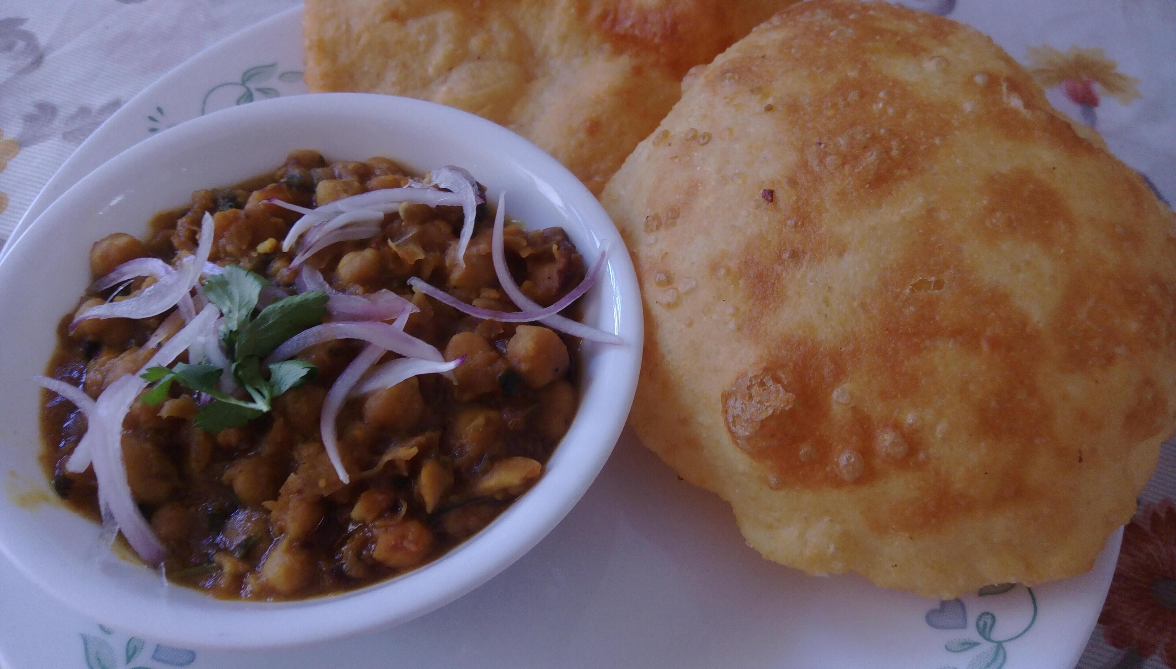 A plate with a bowl of food and two pieces of bread.