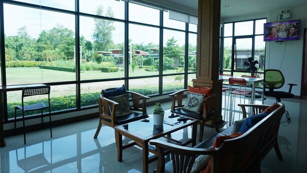 Una habitación amplia con ventanas grandes, una mesa de madera y asientos cómodos.