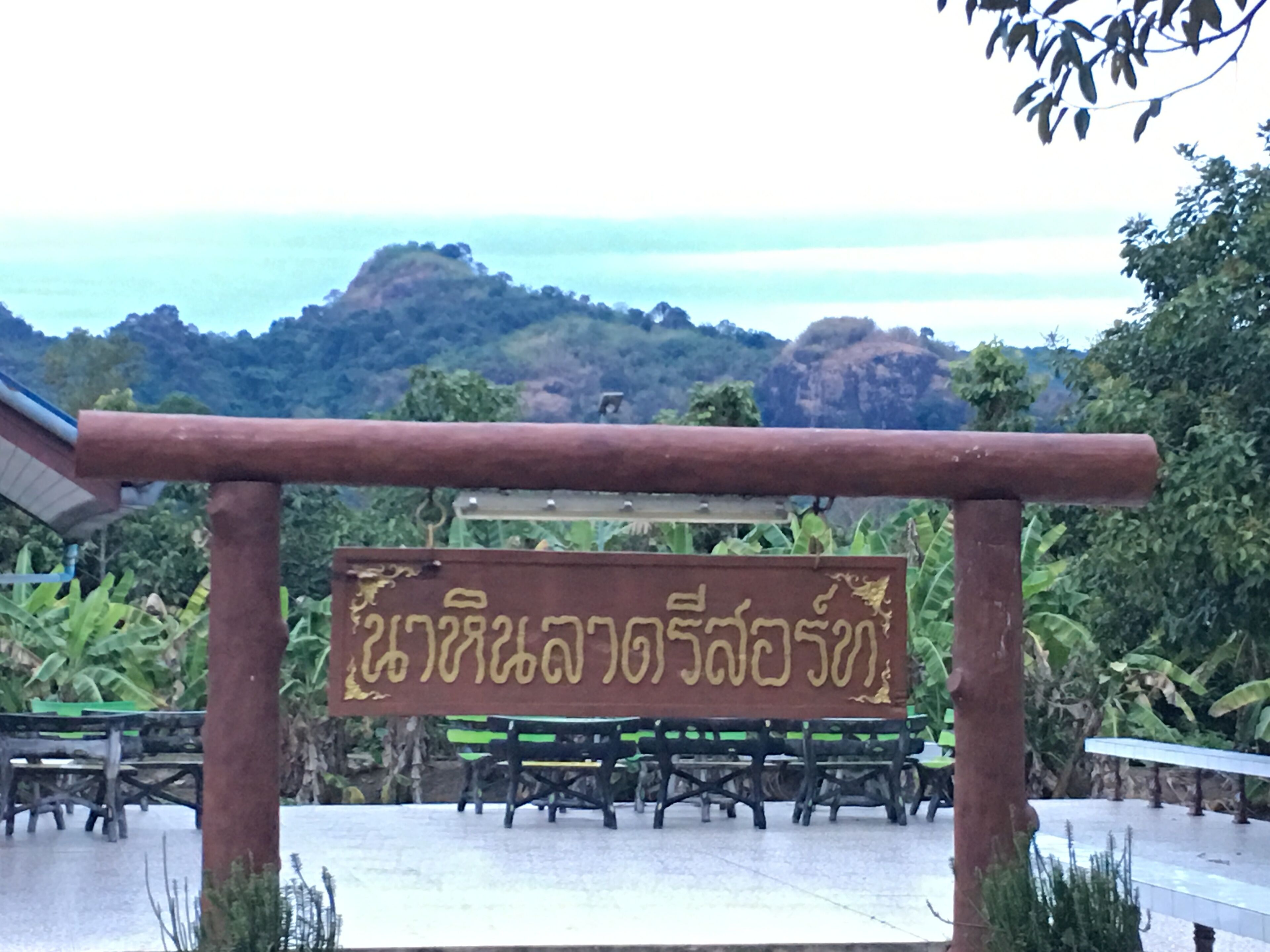 Um sinal com texto em um alfabeto não latino, possivelmente indicando um local ou nome.