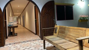 A hallway with a wooden bench, a reception desk, and a sign indicating a VIP area. - Nahinlad Resort (Pak Phli)