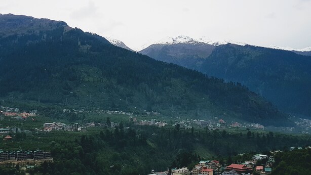 Un paisaje montañoso con un pueblo enclavado en el valle.