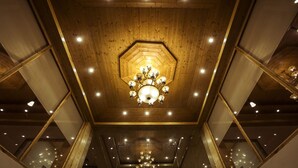 A high-ceilinged room with a central octagonal wooden ceiling and multiple chandeliers. - Primo Resorts (Manali)