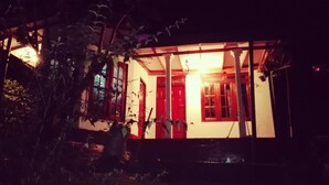 A building with a porch and red doors, surrounded by vegetation. - St Clair Holiday Home (Nuwara Eliya)