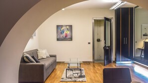 A modern living room with a grey sofa, a glass coffee table, and a painting on the wall. - Seaside Caracciolo (Naples)