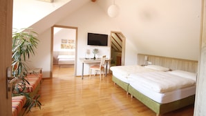 A bedroom with a bed, a desk, and a chair. There is a television on the wall. - Am Treidelpfad (Hassmersheim)