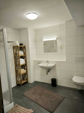 Klassiek appartement | Badkamer | Een douche, een haardroger, handdoeken