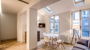 Un appartement moderne doté d’un coin repas, d’un canapé et offrant une vue sur l’extérieur.