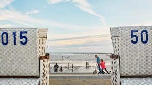 Une promenade en bord de mer, avec deux panneaux numérotés, les numéros 015 et 50, qui mènent à l’eau.