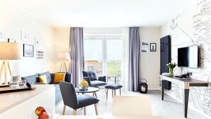 Une chambre d’hôtel moderne dotée d’un espace salon, d’un coin repas et d’un balcon avec vue.