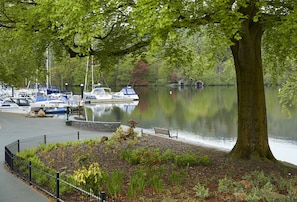 A marina with boats docked, a stone wall, and a bench by the water.