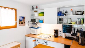 A compact kitchen with a microwave, coffee maker, and various utensils on shelves. - Air-conditioned 3-Room Pavilion with Terrace, Parking, and Wi-Fi - Sleeps 4 (Narbonne-Narbonne Plage-Narbonne Plage)