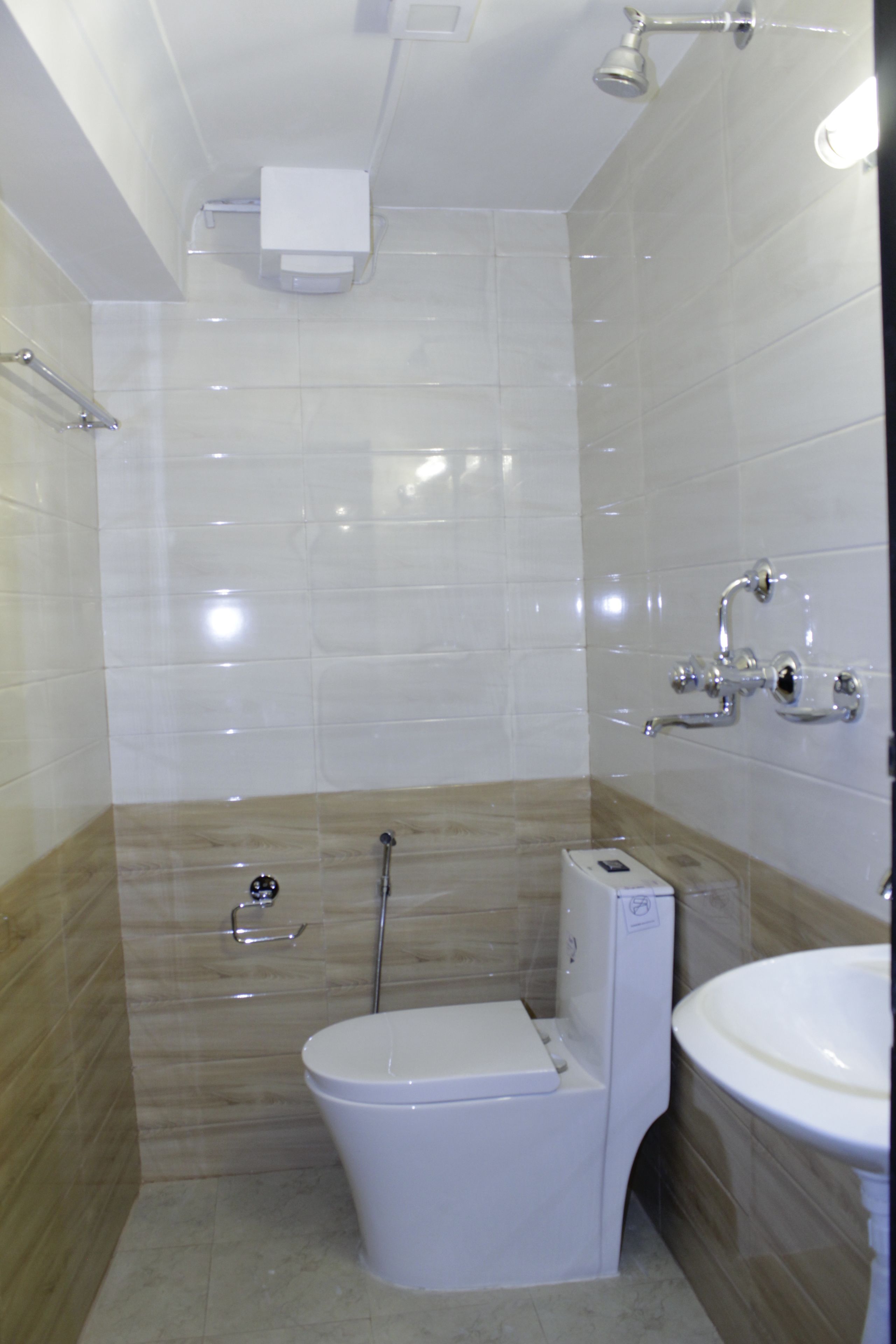 A small, modern bathroom with a toilet, a shower, and a sink.