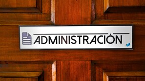 Un cartel con la palabra 'ADMINISTRACIÓN' en una puerta de madera.