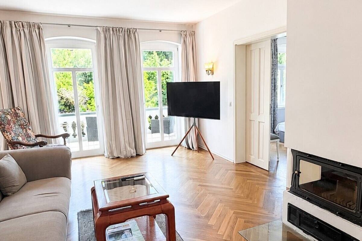 Een woonkamer met een bank, een salontafel, een televisie en een open haard.