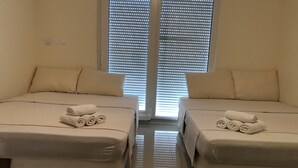 A hotel room with two beds, each with a rolled towel on the bed. - Atrium Novalja (Novalja)