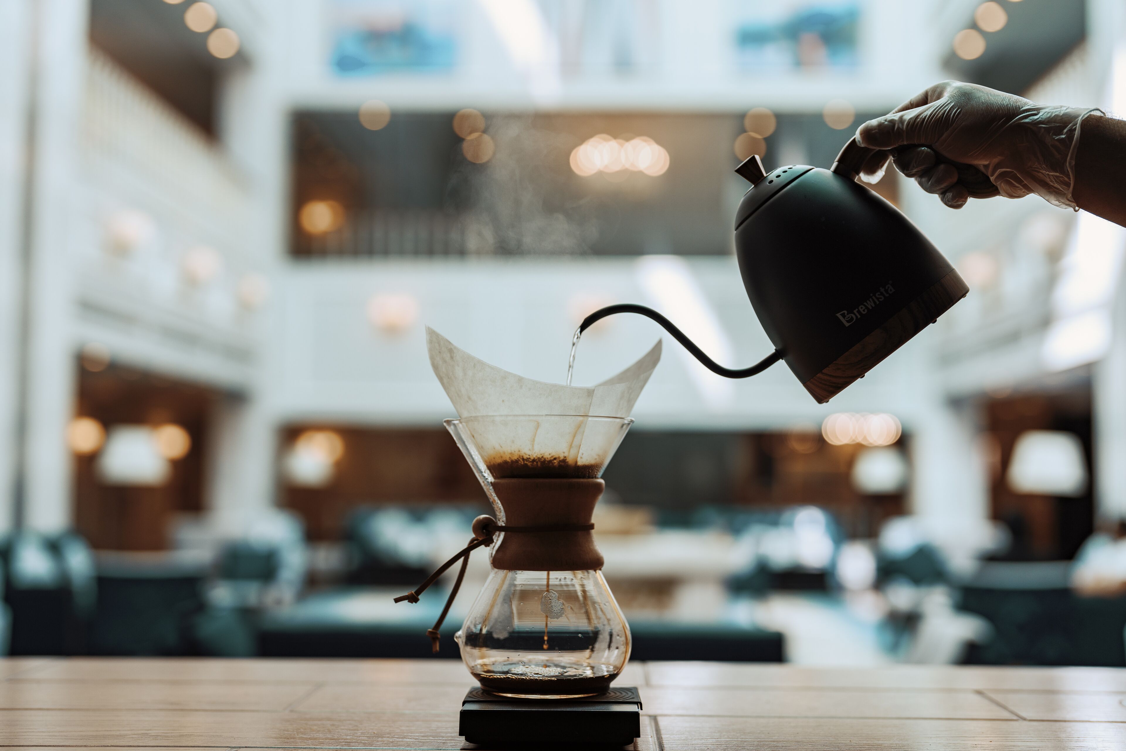 Una cafetera sobre una mesa en un ambiente interior moderno.