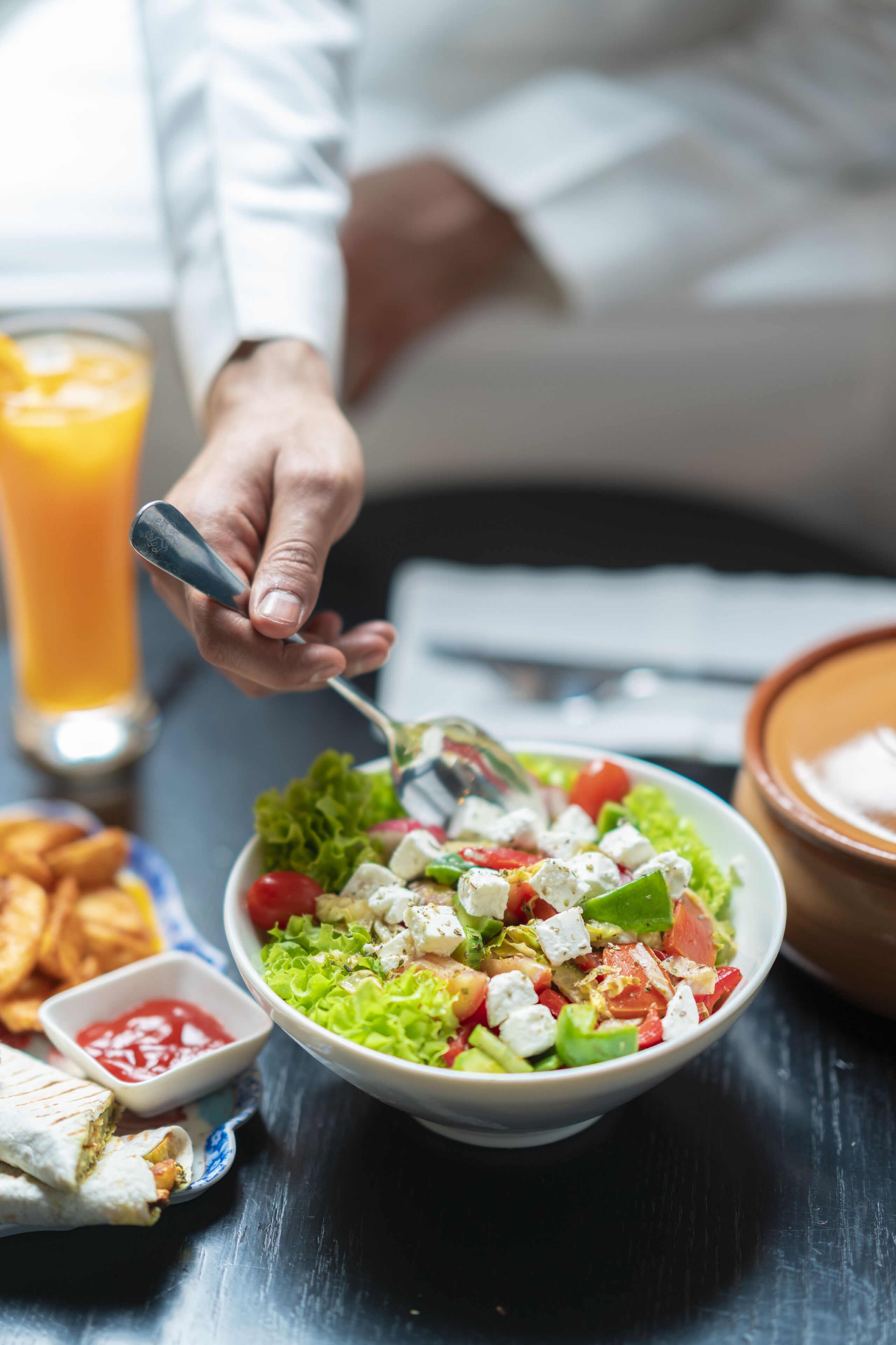 Alguém servindo uma salada com um garfo.